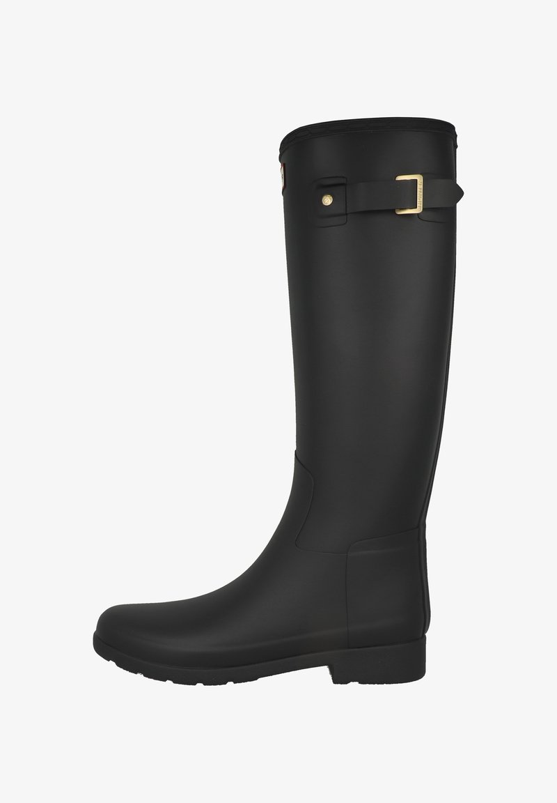 Svart gummistövel upp till knät, vattentät, med rundad tå, texturerad ovandel och en guldfärgad spänndetalj på sidan. Hållbar sula för bra grepp.