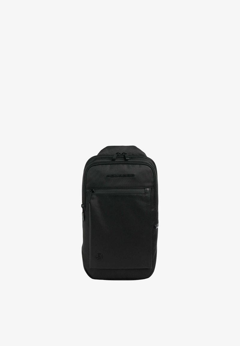 Sac à dos noir avec un tissu texturé, plusieurs compartiments zippés, des accents lisses et un logo sur la section inférieure avant.