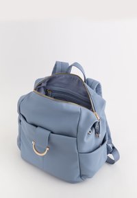 Mochila de cuero texturizado azul con herrajes en tono dorado, cierre con cremallera, bolsillo frontal y correas ajustables. El interior cuenta con múltiples compartimentos.