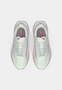 Baltos sportinės bėgimo bateliai su tekstūruotu viršumi, rausvais akcentais ir paminkštintu padu, turintys kelis ventiliacijos skylius ir suvarstymo dizainą.