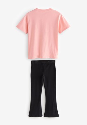 Różowy bawełniany t-shirt z okrągłym dekoltem i krótkimi rękawami, w połączeniu z czarnymi elastycznymi legginsami z logo na pasku i rozszerzanymi mankietami.