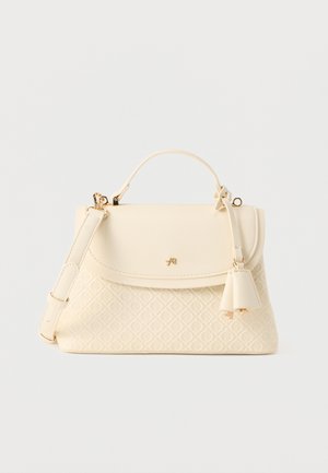 Sac à main couleur crème avec motif matelassé, logo doré, poignée supérieure, bandoulière amovible et pampilles en cuir décoratives sur fond blanc.