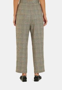 Pantalons à carreaux en tissu gris, noir et multicolore. Coupe décontractée avec une jambe droite, finis avec une taille lisse et sans fermetures visibles.