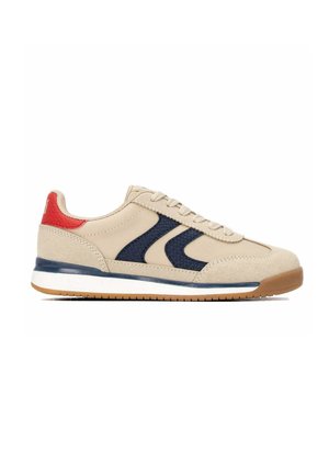 Zapatilla beige con detalles en azul marino, lengüeta roja en el talón, entresuela blanca, suela de goma y cierre de cordones mostrada en perfil lateral.
