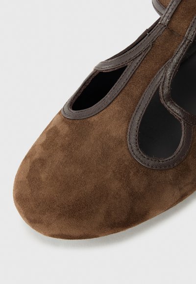Brown suede shoe with cut-out design, brown leather trim, and a rounded toe. Soft texture and open sides for breathability.