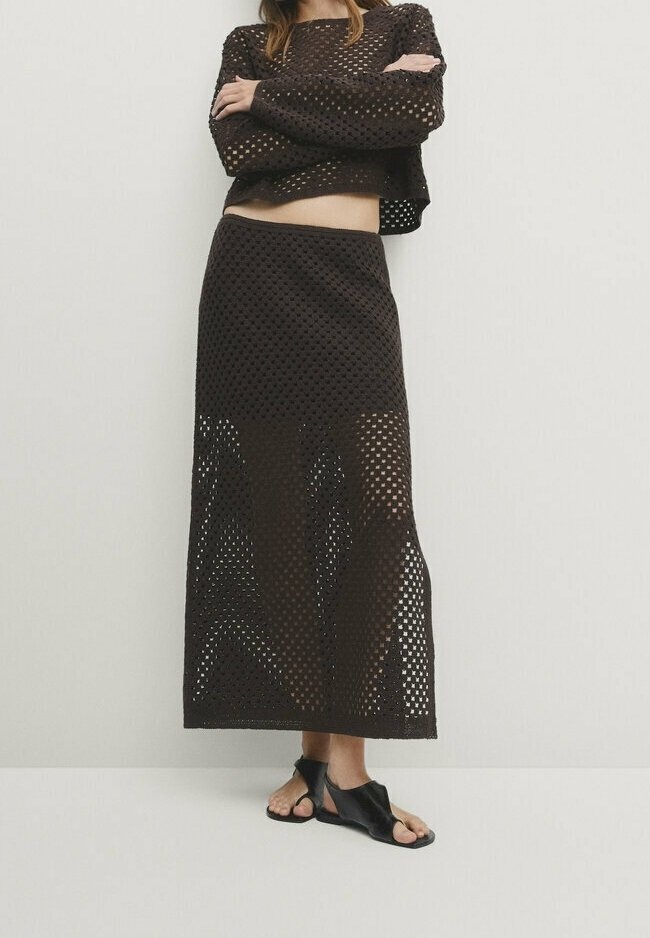 Braunes zweiteiliges Strickset mit einem cropped Langarmoberteil mit quadratischem Ausschnitt und einem langen Rock mit ähnlichem offenem Strickmuster.