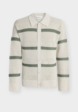 Kremowy kardigan z dzianiny z zielonymi poziomymi paskami, zapinany na guziki z przodu, z kołnierzykiem i ażurowym wzorem na całej powierzchni.