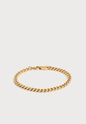 Bracelet chaîne en métal ton or avec maillons entrelacés et fermoir mousqueton sur fond blanc uni.