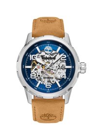 Timberland automātiskā pulksteņi ar zilu ciparnīcu, sudraba korpusu un brūnu ādas siksniņu. Iespējas atklātā mehānika un izteiksmīgi stundu marķējumi.