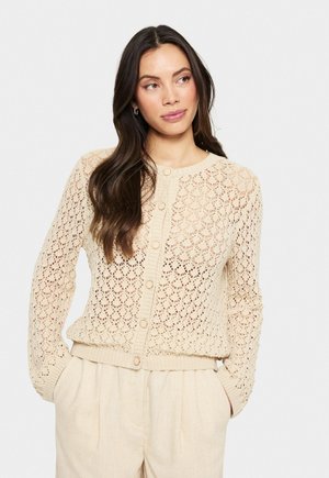 Cardigan beige tricoté avec un motif en dentelle ouvert, col rond, manches longues et fermeture à boutons sur le devant avec des poignets côtelés.