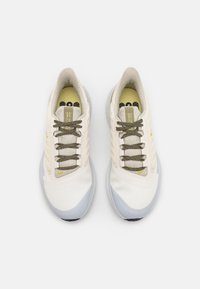 Zapatillas deportivas blancas con acentos gris claro, cordones texturizados y una plantilla con diseño. Suela acolchada para mayor comodidad y soporte.