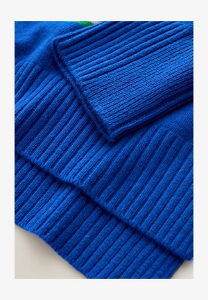 Vouwbare blauw geribbelde stof breigoed, met gedetailleerde textuur en stiksels in close-up.