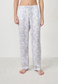 Lichte pyjamabroek van zachte stof, met een bloemenpatroon in blauw op een cream achtergrond, met een trekkoord in de taille en zijzakken.