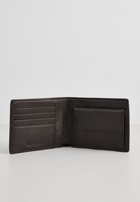 Cartera de cuero marrón con múltiples ranuras para tarjetas y un bolsillo lateral, que presenta una textura suave y bordes cosidos. Se abre para mostrar el diseño interior.