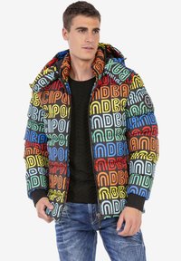 Multicolor opblaasjack met gedurfde, herhalende logo ontwerpen. Met rits aan de voorkant, verstelbare capuchon en geribbelde manchetten. Zwarte binnenkant.