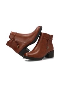 Botines de cuero marrón hasta el tobillo con punta redonda, tacón bajo tipo bloque y detalle decorativo de cordón en la parte trasera. Textura suave, diseño minimalista.