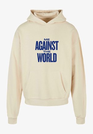 Beige huppari, jossa on etutasku, jossa on rohkeaa sinistä tekstiä, joka sanoo "MINÄ VASTAAN MAAILMA" rinnan kohdalla. Painava kangas, rento malli.