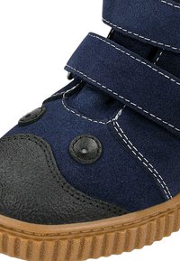 Scarpa blu navy in tessuto con punta nera testurizzata, dotata di due cinturini in Velcro regolabili, cuciture bianche a contrasto e suola in gomma.
