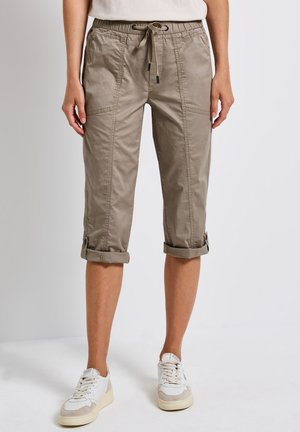 Khaki-Latzhosen mit elastischem Bund und Kordelzug. Merkmale sind umgeschlagene Säume, seitliche Taschen und eine glatte Stofftextur.