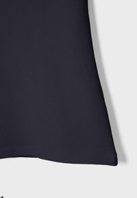 Tissu bleu marine foncé avec un ourlet propre et droit, présenté sur un fond gris clair.