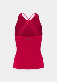 Top sportivo rosso con un design aderente, spalline incrociate e una piccola accentatura del logo sul retro. Tessuto liscio con materiale elastico.