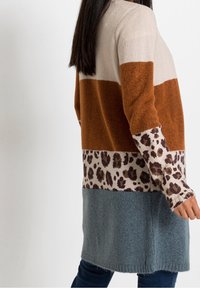 Färgglad tröja i block med bruna, beige och blå sektioner samt en leopardmönstrad detalj. Tillverkad av mjukt stickat tyg med en avslappnad passform.