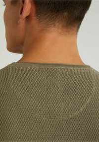 Olivgrüner Strickpullover von hinten betrachtet, mit strukturiertem Muster und rundem Halsausschnitt sowie einer gestickten Detail am Rücken.