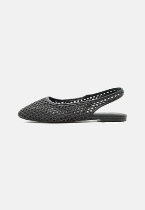Chaussure plate noire à bride arrière avec un design en maille tissée ouverte et bout pointu sur fond uni.