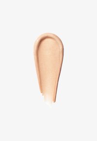 Échantillon de crème de maquillage beige lisse et scintillante avec des bords arrondis sur un fond blanc uni.