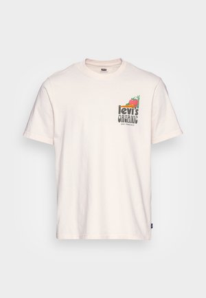 T-shirt en coton biologique couleur crème avec un imprimé graphique "Levi's Organic" et des dessins colorés de légumes sur la zone de la poche poitrine.
