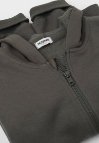 Šedá mikina na zip s vysokým límcem, vyrobená z měkké látky. Má hladký zip a štítek s nápisem "TEZENIS KIDS."