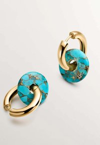 Pendientes de resina turquesa con acentos de metal dorado, que presentan formas circulares y un patrón veteado, destacando un acabado brillante.