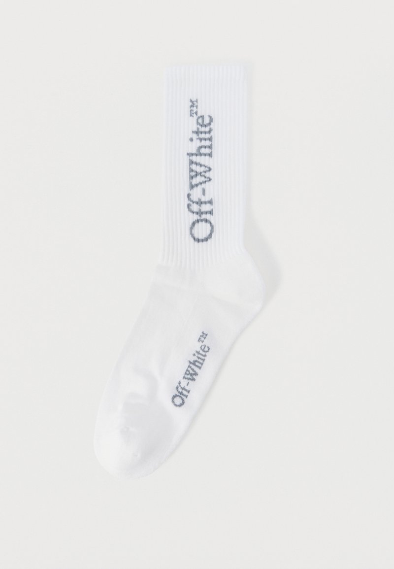 Chaussette blanche montant jusqu'au mollet avec le texte "Off-White" imprimé en noir verticalement sur le mollet et horizontalement près de la zone des orteils.
