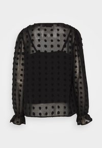 Blusa nera trasparente con maniche lunghe, texture a pois e polsini arricciati. Presenta un collo a barchetta e un design a strati.