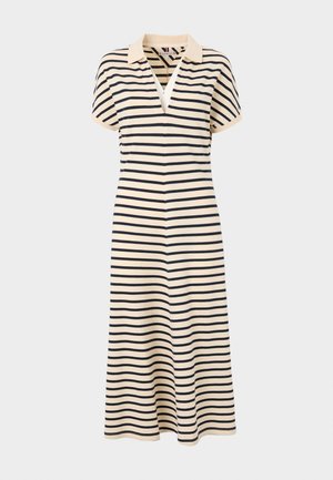 Cette robe rayée présente un col en V, des manches courtes et une longueur jusqu'aux genoux. Fabriquée en tissu léger avec des rayures crème et bleu marine.