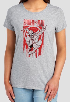 Woman wearing a light gray t-shirt with red Spider-Man graphic of crouching Spider-Man and cityscape in background.
