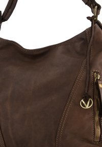 Braune Lederhandtasche mit weicher Textur, die über eine Reißverschlusstasche und kontrastierende Nähte verfügt. Enthält einen Schulterriemen mit einem Messingakzent.