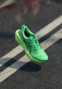 Scarpa da corsa leggera in rete neon verde vibrante con dettagli neri. Presenta una suola ammortizzata e una grip testurizzata, progettata per le prestazioni.