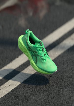 Zapatilla de correr ligera en malla verde neón vibrante con acentos en negro. Cuenta con una suela acolchada y un agarre texturizado, diseñada para el rendimiento.