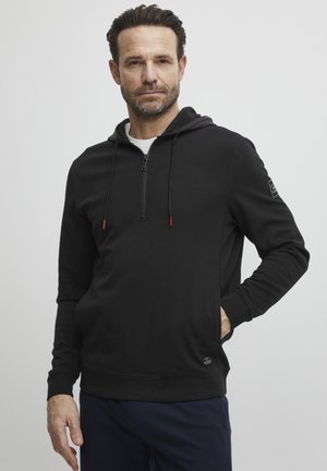 Black zip-up hoodie made of soft fabric, featuring a front pocket, red zipper accents, and a fitted design. Simple, solid color without patterns.