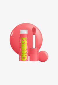 Blush liquide corail dans un tube transparent avec un applicateur doux. Étiquette jaune vif ; arrière-plan corail rond ; texture lisse.
