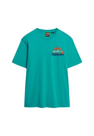 T-shirt en coton turquoise avec un col rond, des manches courtes et un graphisme de logo avec des montagnes sur la poitrine gauche.