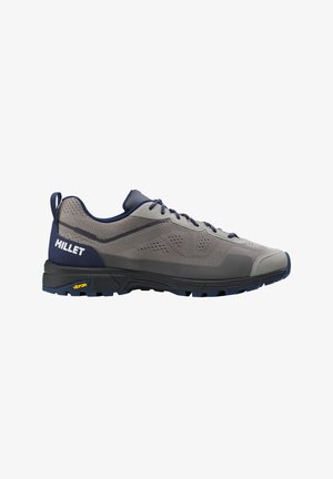 Gray and navy low-top hiking shoe with textured sole, laces, pull tab at heel, and "Millet" logo on side.