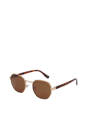 Zonnebril met gouden montuur, bruine getinte glazen en armen met schildpaddentegelpatroon, rustend op een wit oppervlak.