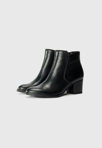 Botas de cuero negro hasta el tobillo con un acabado suave, punteras redondeadas y un tacón ancho y resistente. Presenta un diseño con costuras mínimas y sin hardware visible.