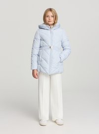 Giacca imbottita azzurro chiaro con cappuccio, cintura in vita e chiusura con zip; presenta trapuntature diagonali e due tasche laterali. Abbinata a pantaloni bianchi a gamba larga.