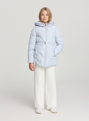 Giacca imbottita azzurro chiaro con cappuccio, cintura in vita e chiusura con zip; presenta trapuntature diagonali e due tasche laterali. Abbinata a pantaloni bianchi a gamba larga.