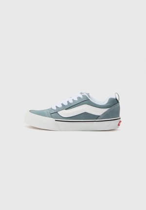 Blauwe suède sneakers met witte accenten, ronde neus, veters en een zwarte streep op de zool. Voorzien van een logo achterop en een gevoerde binnenkant.