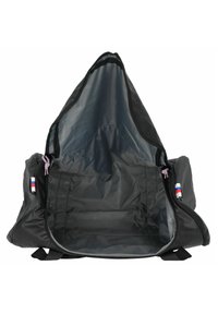 Zaino nero dalla forma triangolare, con un ampio interno foderato in tessuto grigio. Include dettagli colorati in corda sulle cerniere.