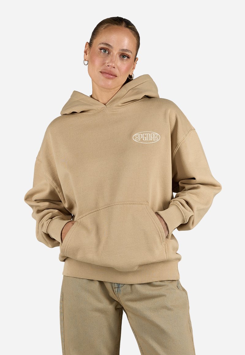 Hanorac oversized bej, cu un buzunar frontal și logo brodat. Fabricat dintr-un amestec moale de bumbac, având o glugă cu șnur și manșete din tricot.